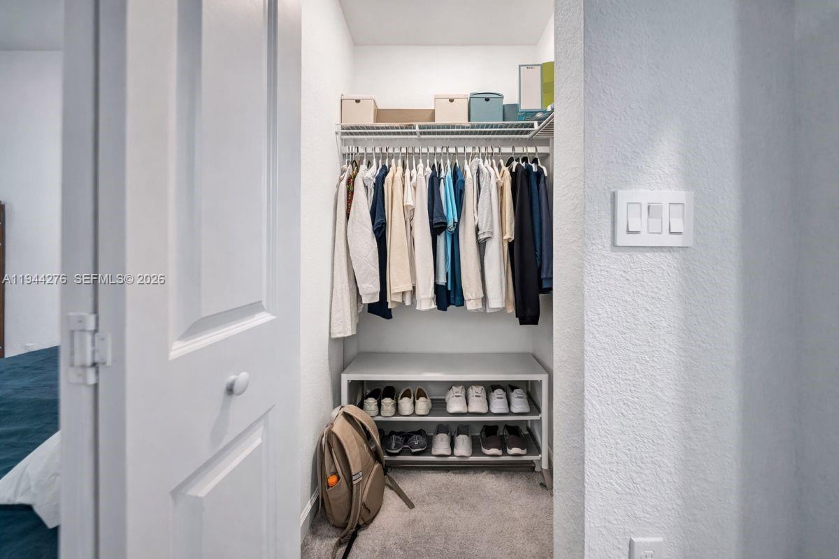 24985 Southwest 107th Court Homestead, FL 33032 - Photo 17 of 22 a view of walk in closet with clothes
