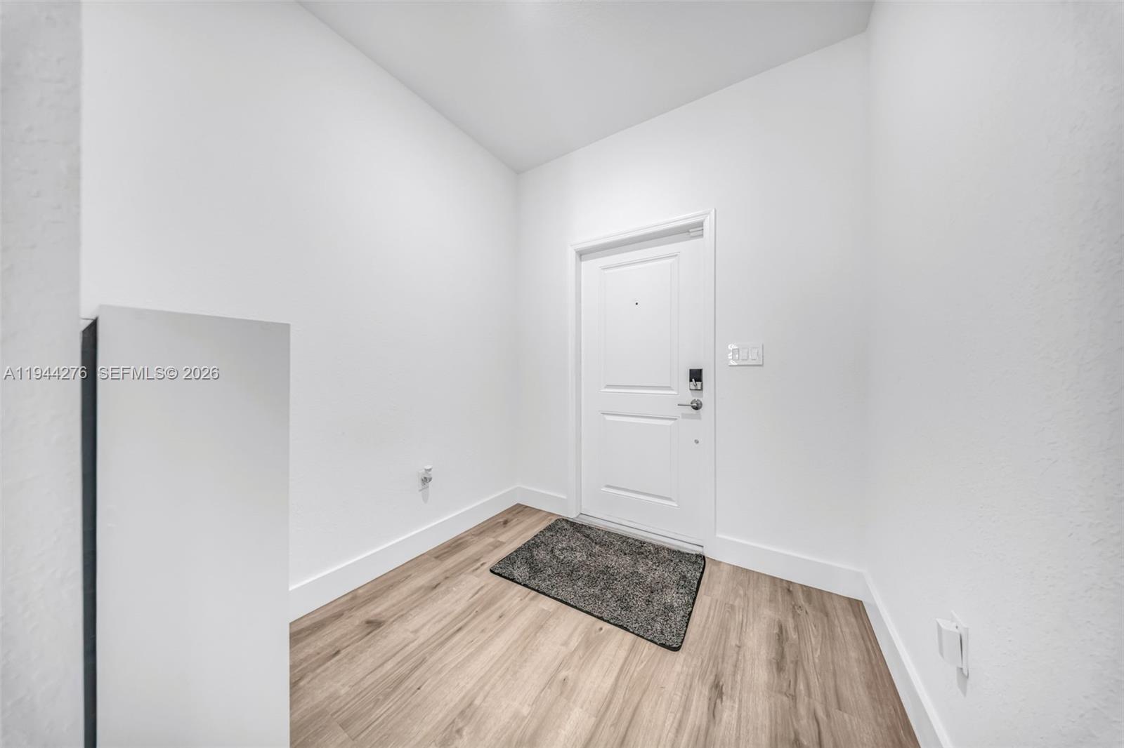 24985 Southwest 107th Court Homestead, FL 33032 - Photo 2 of 22 a view of a room with wooden floor and white walls