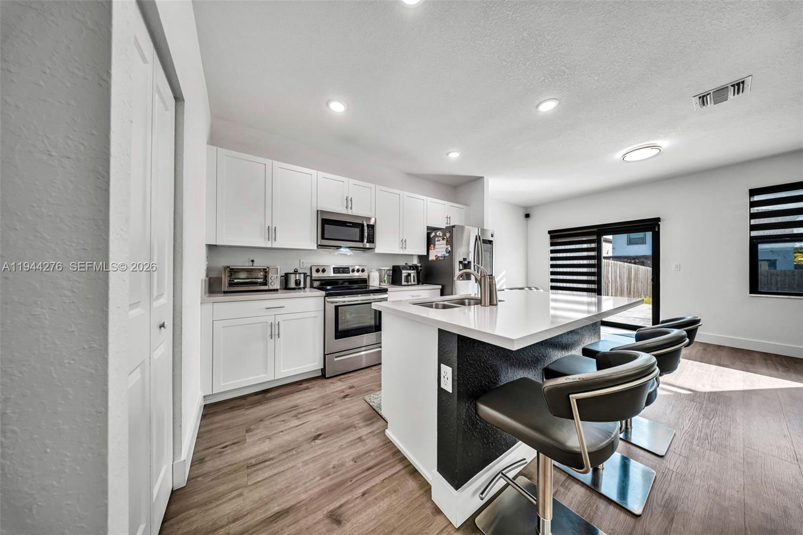 24985 Southwest 107th Court Homestead, FL 33032 - Photo 6 of 22 a kitchen with a dining table chairs appliances and cabinets