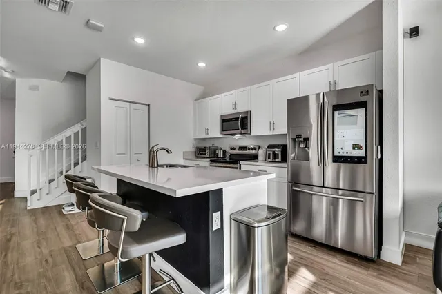 a kitchen with kitchen island a sink appliances and cabinets
