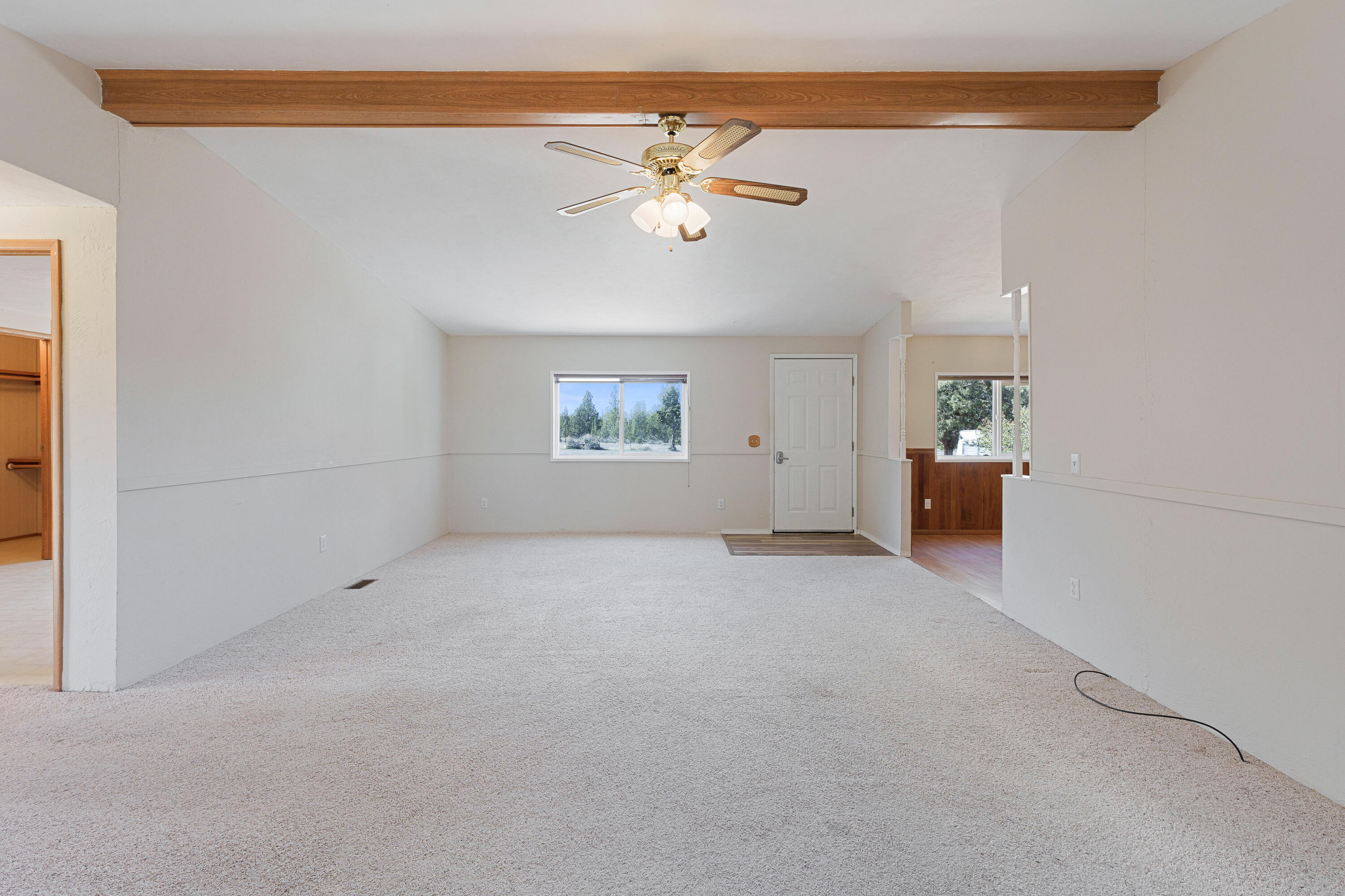 5674 Southeast Davis Loop Prineville, OR 97754 - Photo 6 of 48 an empty room with chandelier fan and windows