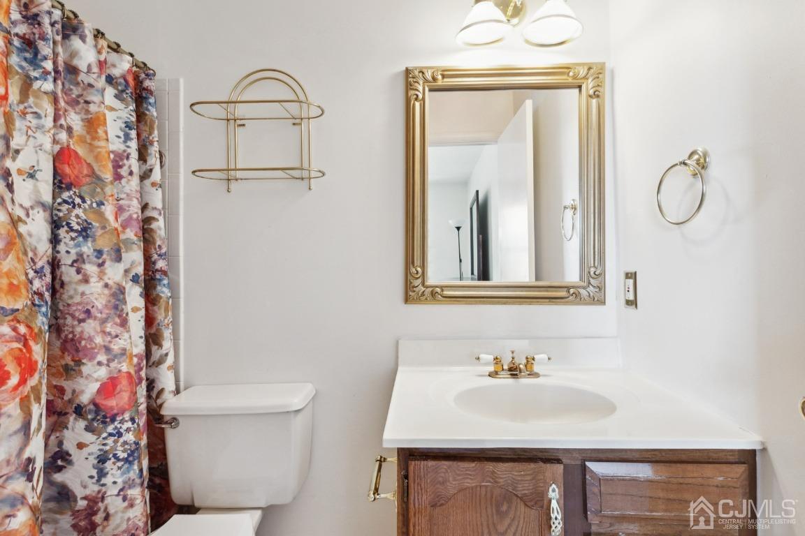 333 Devon Place Morganville, NJ 07751 - Photo 14 of 17 a bathroom with a sink a toilet and a mirror