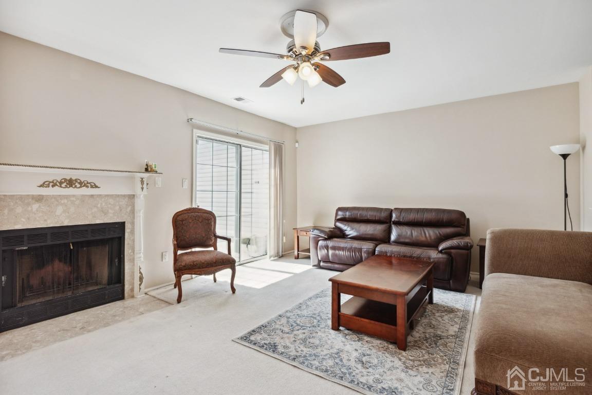 333 Devon Place Morganville, NJ 07751 - Photo 3 of 17 a living room with furniture a flat screen tv and a fireplace
