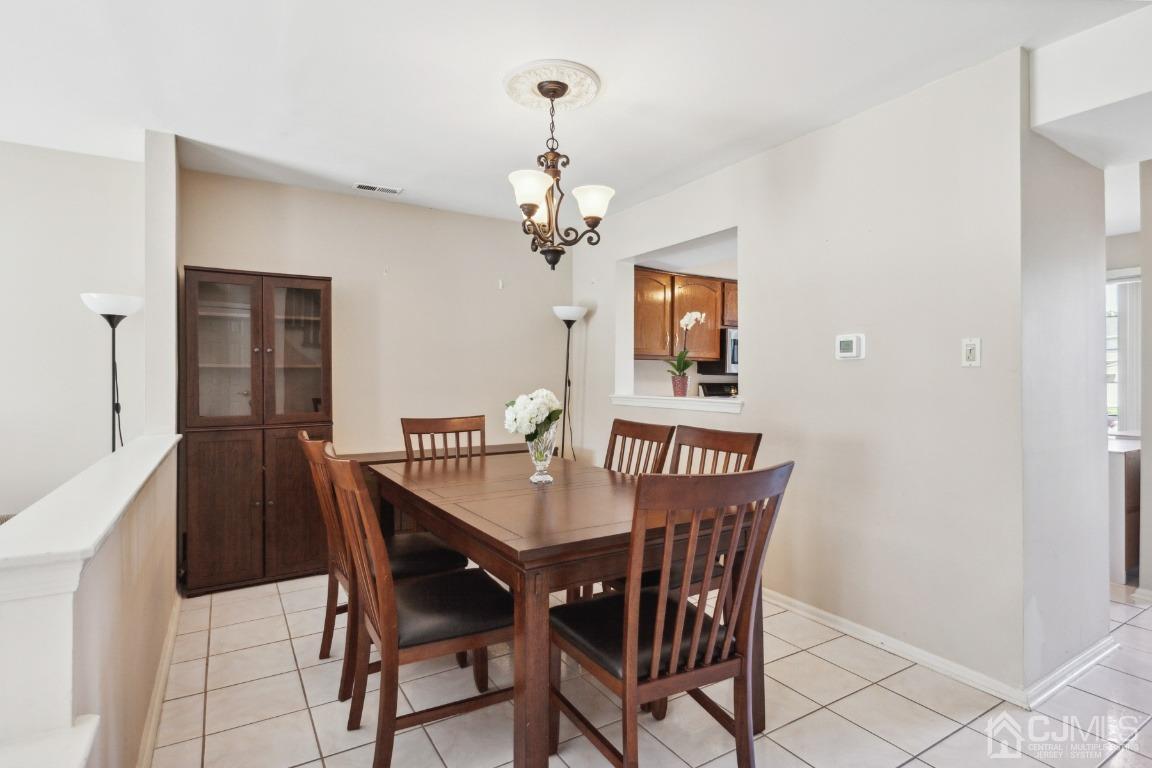 333 Devon Place Morganville, NJ 07751 - Photo 5 of 17 a view of a dining room with furniture a chandelier and wooden floor