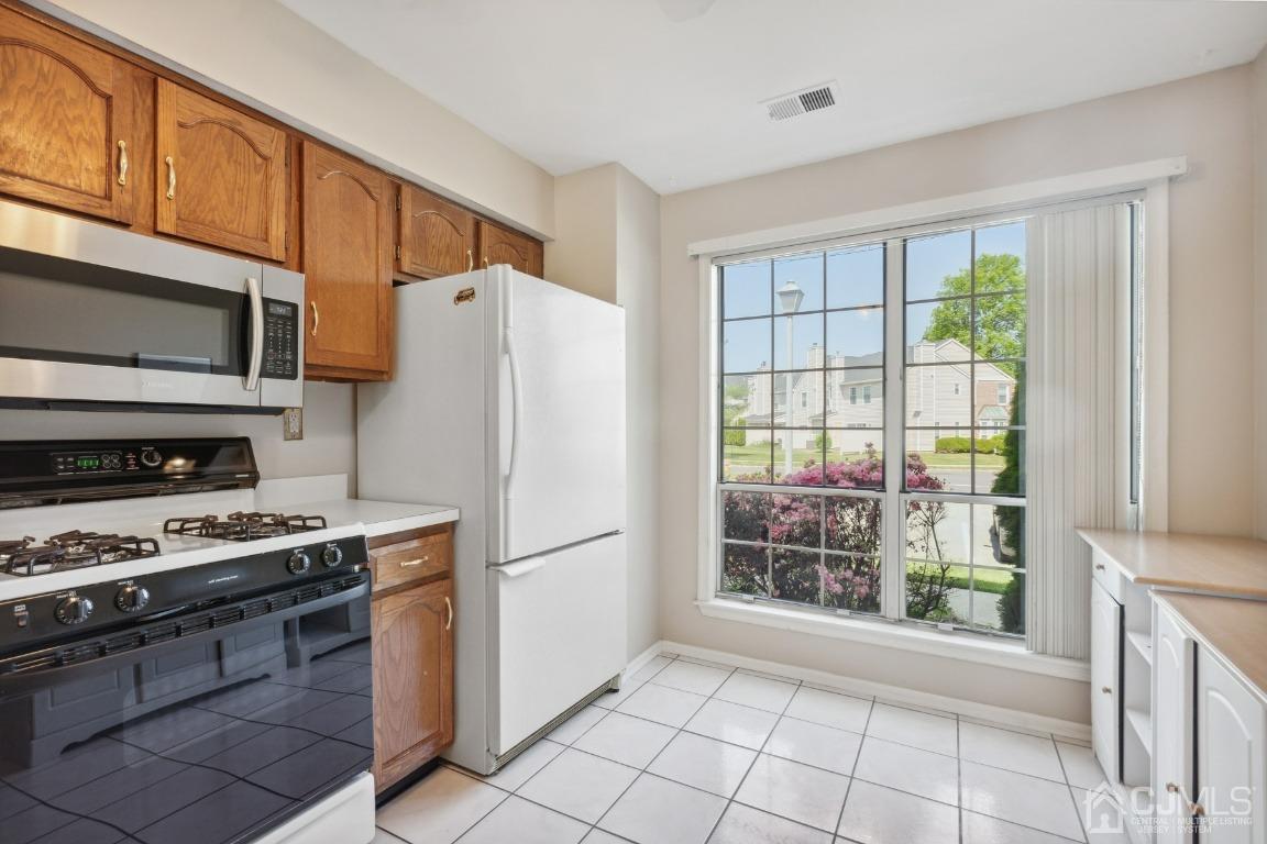 333 Devon Place Morganville, NJ 07751 - Photo 7 of 17 a kitchen with a refrigerator a stove top oven a large window and a refrigerator