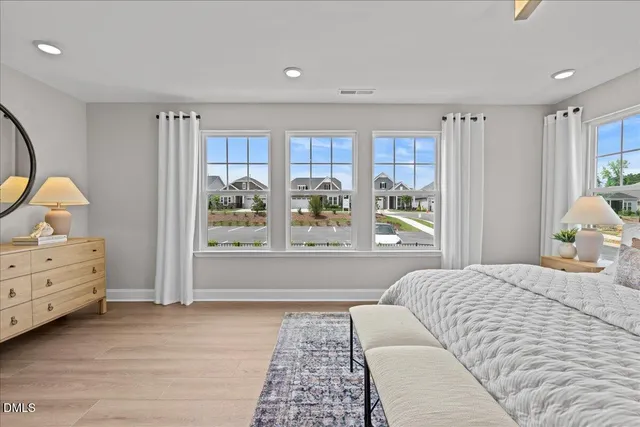 a bedroom with a bed wooden floor and window