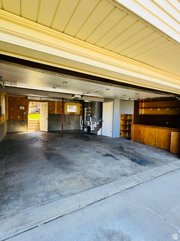 4245 3320 East Holladay, UT 84124 - Photo 46 of 51 Spacious garage featuring a concrete floor, built-in wooden cabinetry, and an interior door