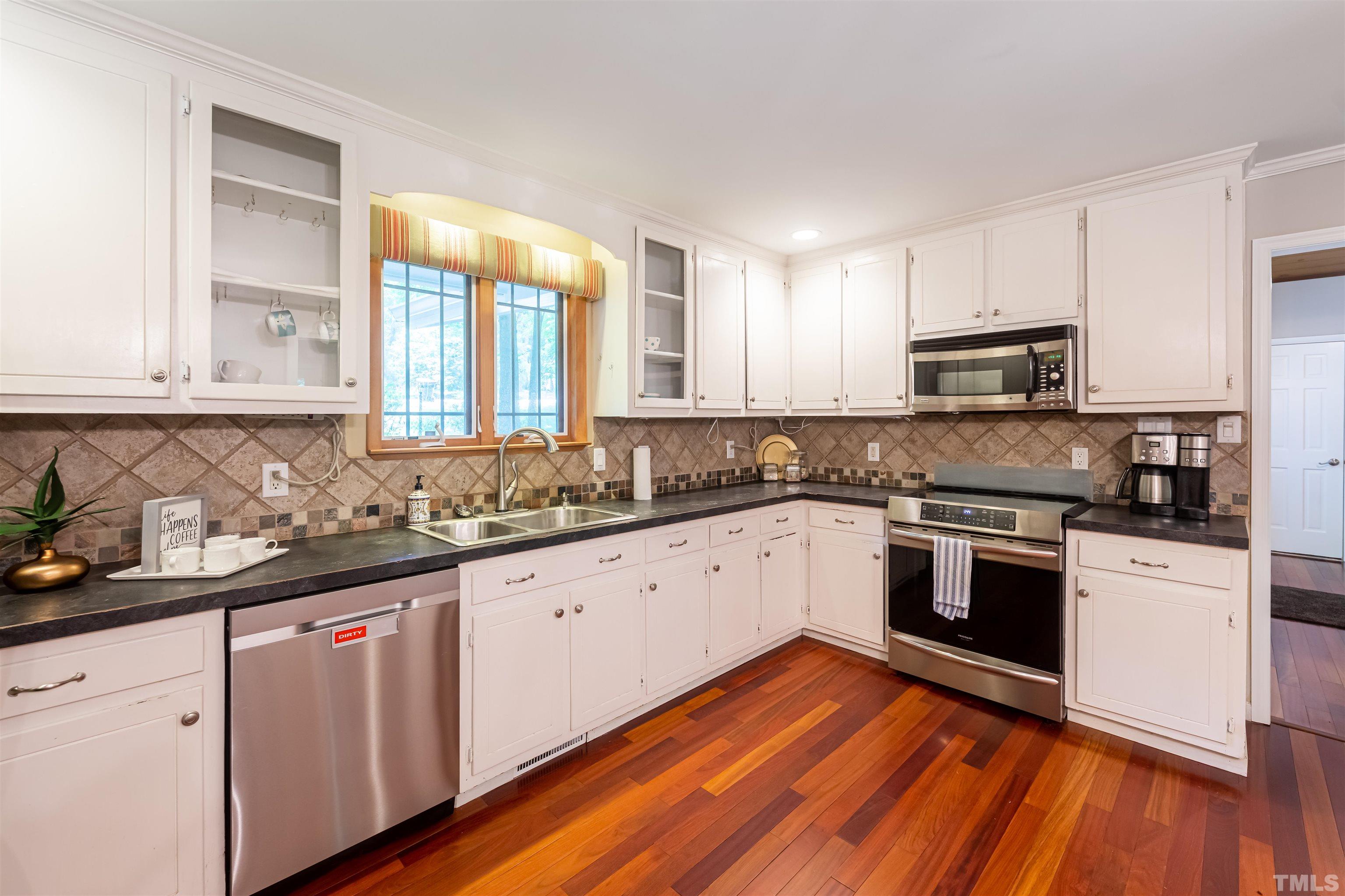 2612 Salisbury Plain Raleigh, NC 27613 - Photo 6 of 22 a kitchen with granite countertop wooden floors and white stainless steel appliances