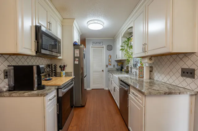 a kitchen with stainless steel appliances granite countertop a sink stove and refrigerator