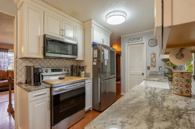 a kitchen with stainless steel appliances a stove a refrigerator and a sink
