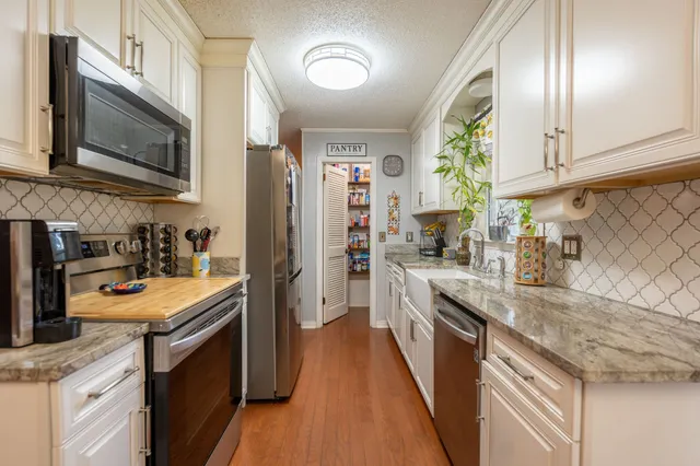 a kitchen with stainless steel appliances granite countertop a sink stove and refrigerator