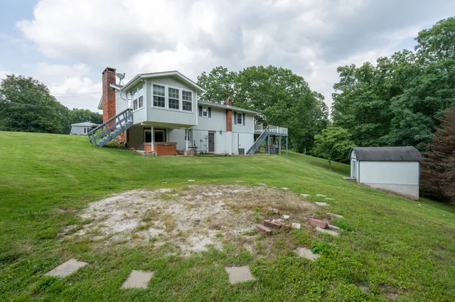 a front view of a house with a garden and trees