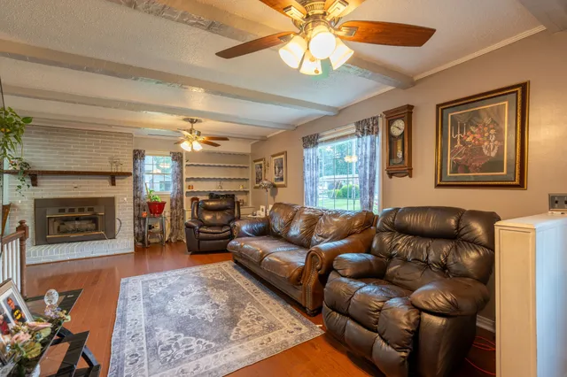 a living room with furniture a fireplace and a flat screen tv