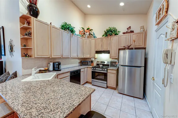 a kitchen with stainless steel appliances granite countertop a sink refrigerator and cabinets