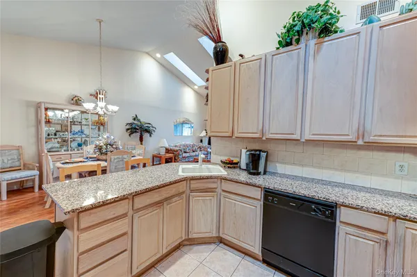 a kitchen with granite countertop a sink stainless steel appliances and cabinets