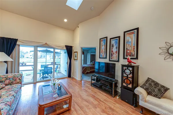 a living room with furniture and a dining table with wooden floor