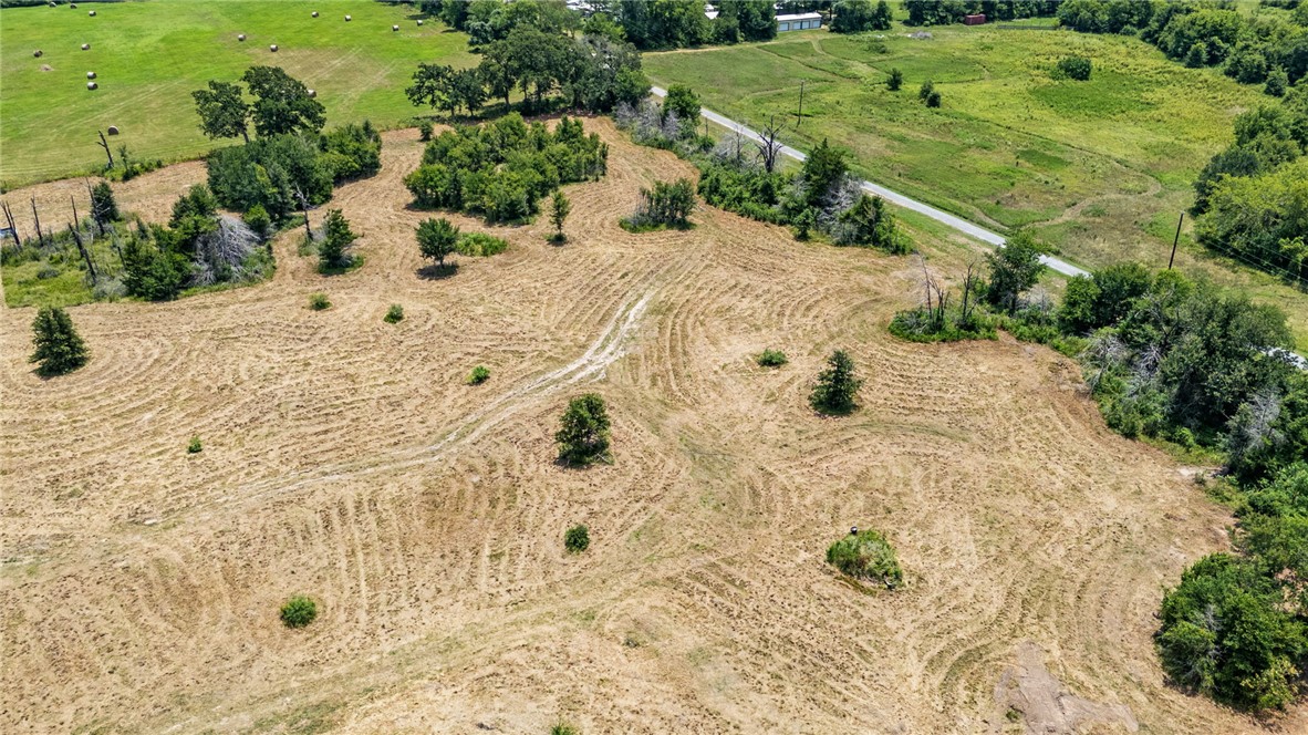 995 Diserens Road North Zulch, TX 77872 - Photo 3 of 41 Expansive open land featuring a cleared field with patterns, scattered mature trees, and a bordering wooded area