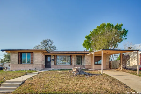 a front view of a house with a garden and patio