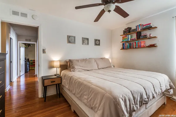 a bedroom with a bed and wooden floor