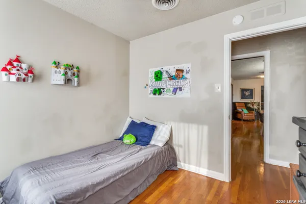 a bedroom with bed and wooden floor