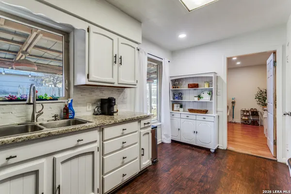 a kitchen with granite countertop white cabinets and white appliances