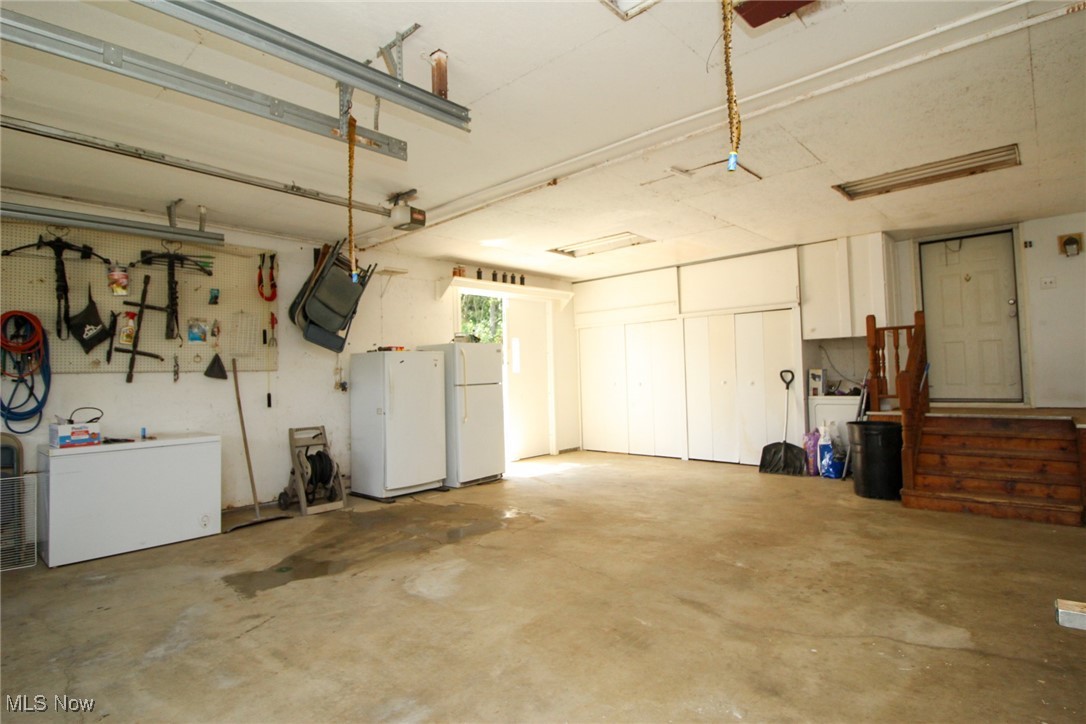 1798 Campbell Road Southwest New Philadelphia, OH 44663 - Photo 9 of 50 Garage with a garage door opener and white refrigerator