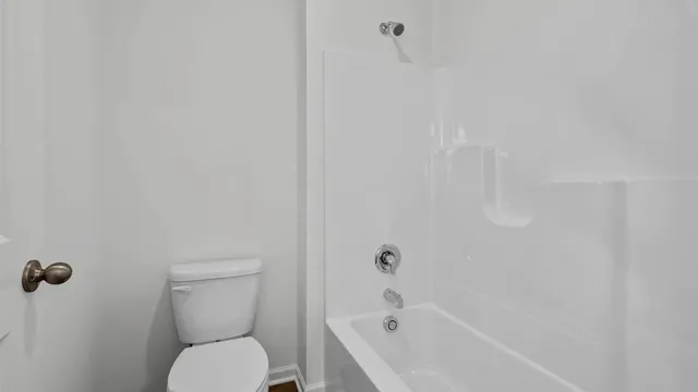 a white toilet sitting next to a bath tub