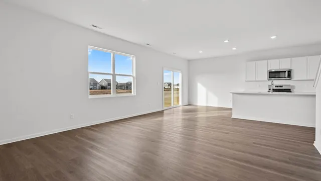 a view of a kitchen with wooden floor and electronic appliances
