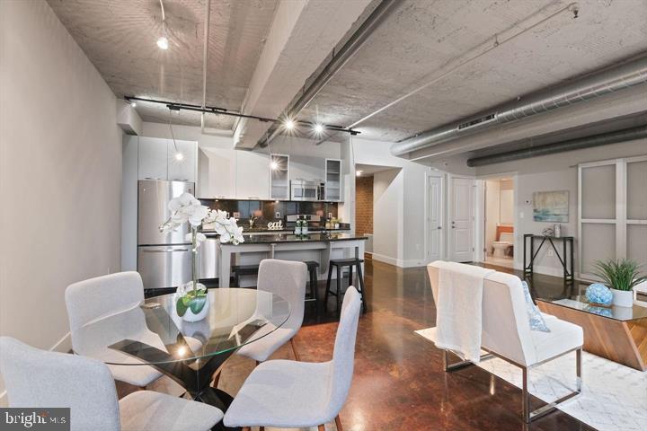 916 G St. Northwest, Unit 602 Washington, DC 20001 - Photo 3 of 11 a kitchen with stainless steel appliances kitchen island granite countertop a dining table chairs refrigerator and sink