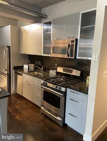a kitchen with stainless steel appliances granite countertop a stove a sink and a refrigerator