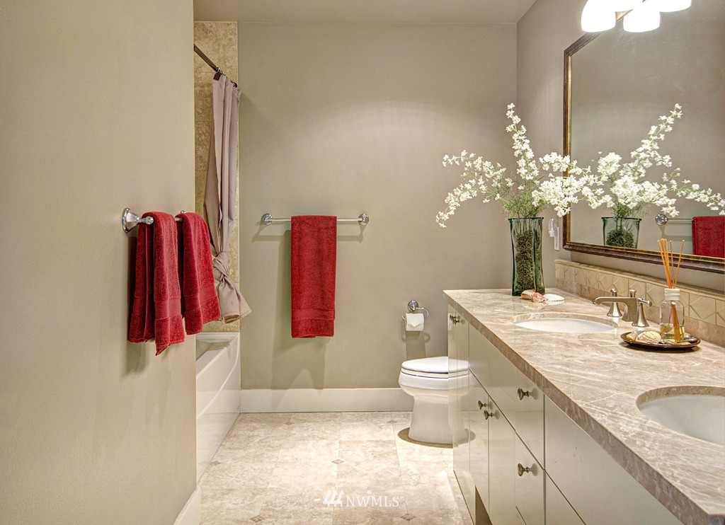 61 Pine Street, Unit 302 Edmonds, WA 98020 - Photo 18 of 25 a bathroom with a granite countertop sink a toilet and a shower curtain
