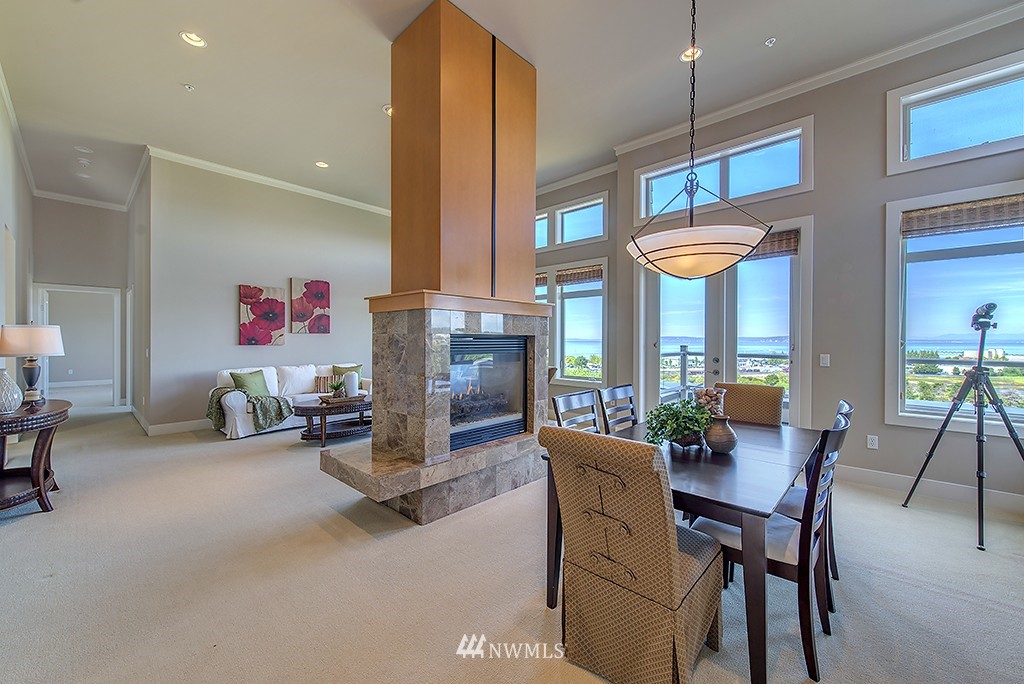 61 Pine Street, Unit 302 Edmonds, WA 98020 - Photo 5 of 25 a dining room with furniture a fireplace and a chandelier