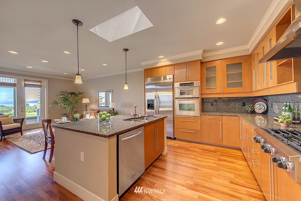 61 Pine Street, Unit 302 Edmonds, WA 98020 - Photo 6 of 25 a kitchen with stainless steel appliances granite countertop a sink and wooden cabinets