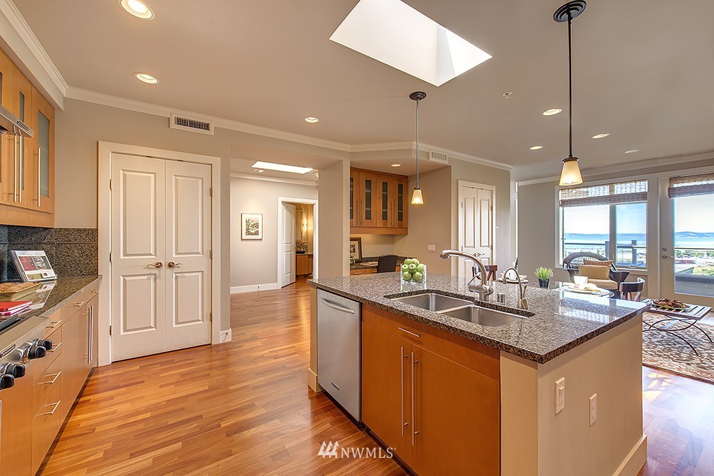 61 Pine Street, Unit 302 Edmonds, WA 98020 - Photo 7 of 25 a kitchen with stainless steel appliances granite countertop a sink a stove and a wooden floors