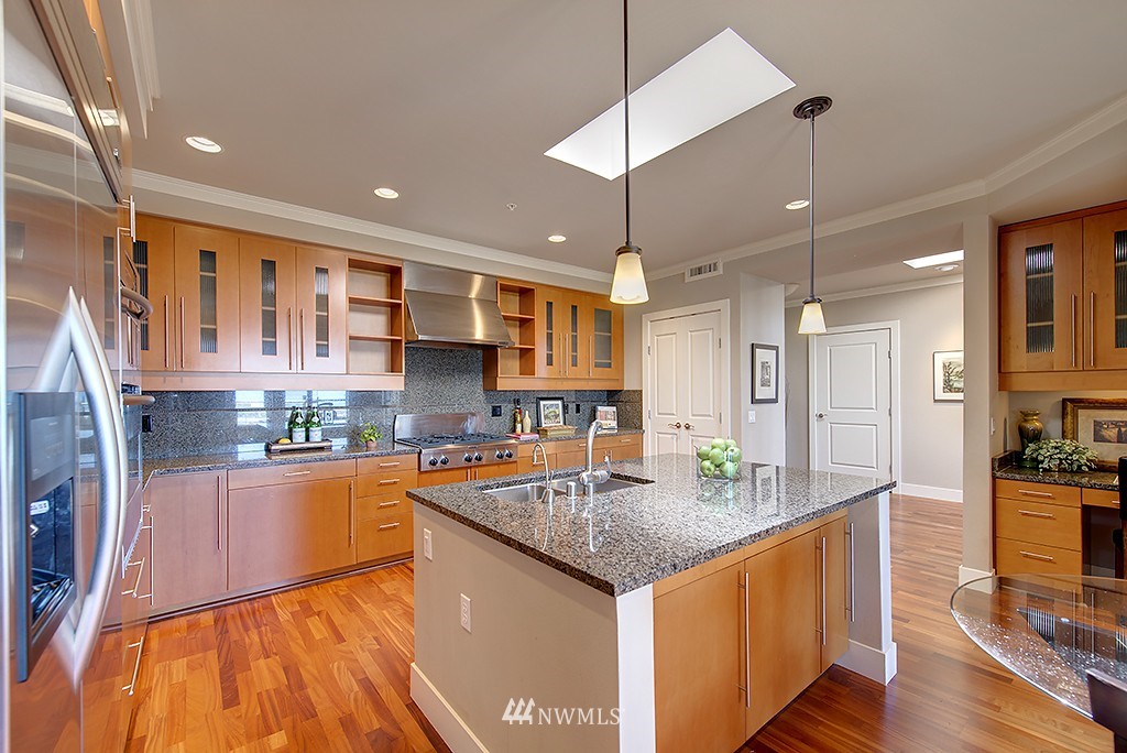 61 Pine Street, Unit 302 Edmonds, WA 98020 - Photo 8 of 25 a kitchen with stainless steel appliances granite countertop a sink and a refrigerator