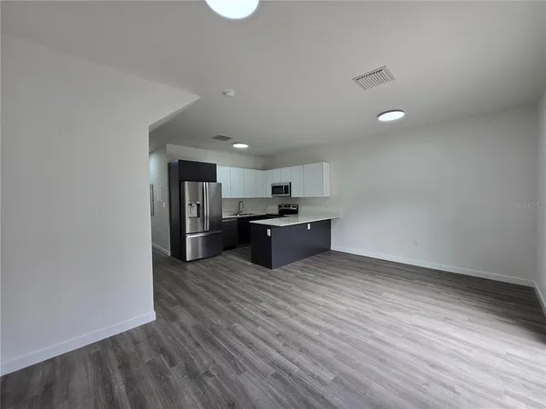 a kitchen with stainless steel appliances a refrigerator sink and microwave