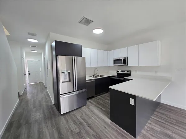 a kitchen with stainless steel appliances kitchen island a refrigerator sink and stove