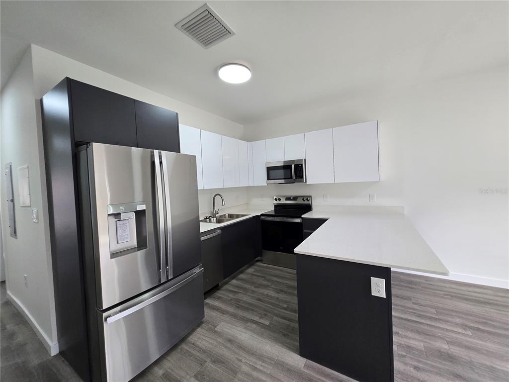1601 Northwest 29 Road, Unit 3 Gainesville, FL 32605 - Photo 13 of 48 a kitchen with stainless steel appliances kitchen island a refrigerator sink and stove