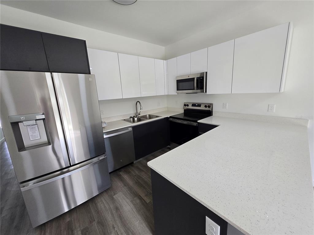 1601 Northwest 29 Road, Unit 3 Gainesville, FL 32605 - Photo 15 of 48 a kitchen with a sink a refrigerator and white cabinets
