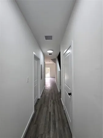 a view of a hallway with wooden floor