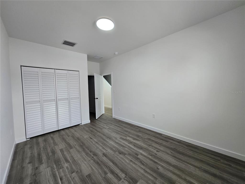 1601 Northwest 29 Road, Unit 3 Gainesville, FL 32605 - Photo 23 of 48 a view of an empty room with wooden floor and closet