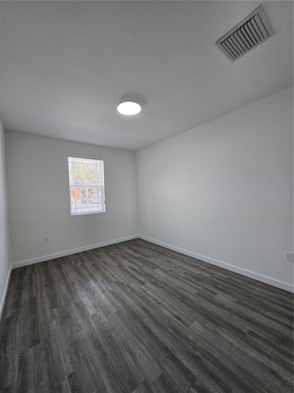 1601 Northwest 29 Road, Unit 3 Gainesville, FL 32605 - Photo 25 of 48 an empty room with wooden floor and windows