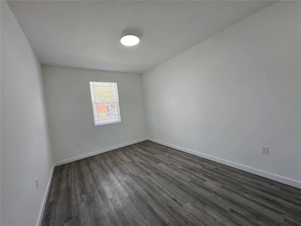 a view of a room with wooden floor and a sink