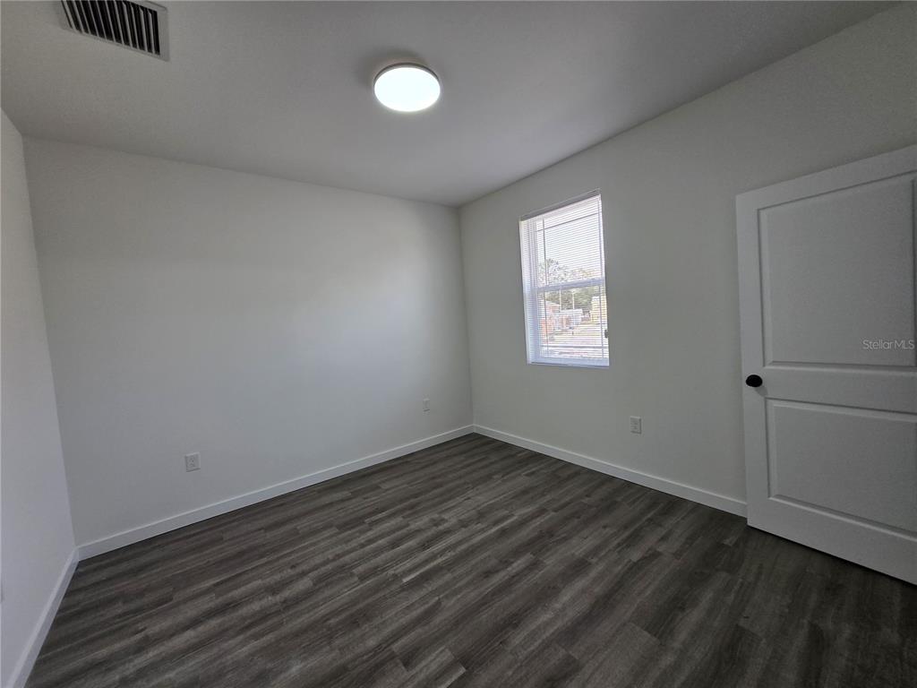 1601 Northwest 29 Road, Unit 3 Gainesville, FL 32605 - Photo 37 of 48 an empty room with wooden floor and windows