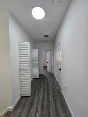 an empty room with wooden floor and closet