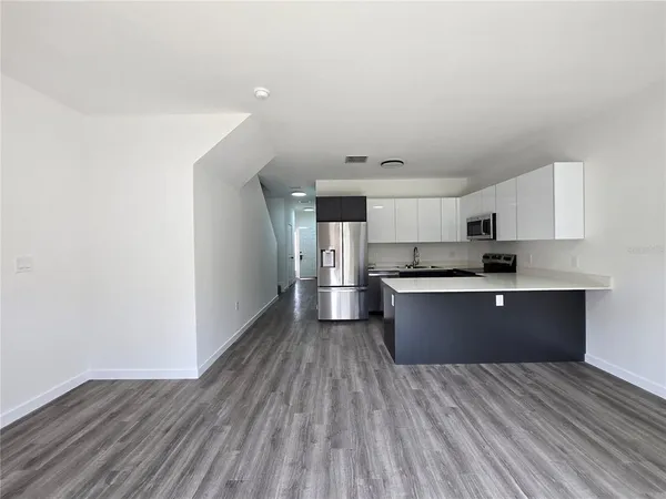 a kitchen with stainless steel appliances granite countertop a sink cabinets and wooden floor
