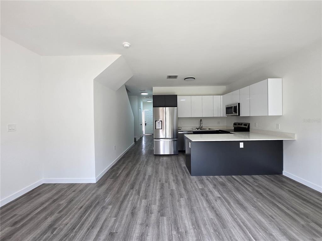 1601 Northwest 29 Road, Unit 3 Gainesville, FL 32605 - Photo 6 of 48 a kitchen with stainless steel appliances granite countertop a sink cabinets and wooden floor