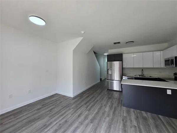 a kitchen with stainless steel appliances a stove and wooden floor