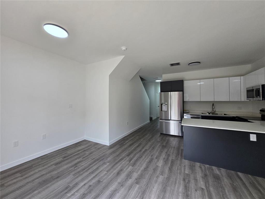 1601 Northwest 29 Road, Unit 3 Gainesville, FL 32605 - Photo 7 of 48 a kitchen with stainless steel appliances a stove and wooden floor