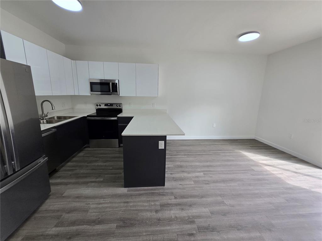 1601 Northwest 29 Road, Unit 3 Gainesville, FL 32605 - Photo 9 of 48 a kitchen with stainless steel appliances a refrigerator sink and stove